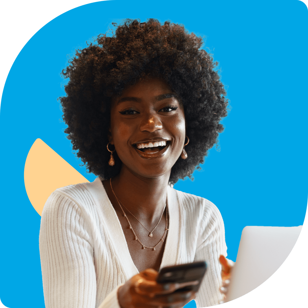 African american woman smiling at camera holding phone