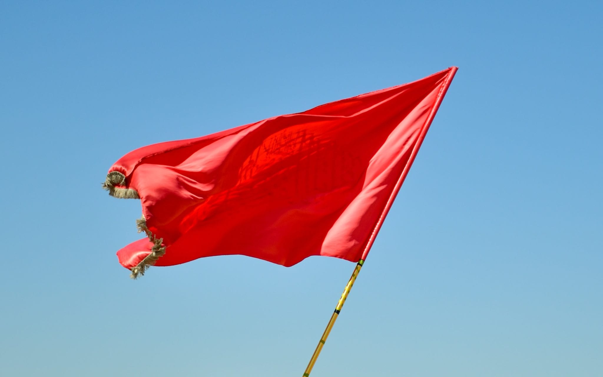 Red flag waving in the blue sky
